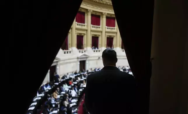 A security guard watches lawmakers debate bill promoted by Argentine President Javier Milei in Buenos Aires, Argentina, Tuesday, April 30, 2024. Congress' lower house is debating a bill promoted by Argentine President Javier Milei that includes a broad range of economic, administrative, criminal, and environmental reforms. (AP Photo/Natacha Pisarenko)