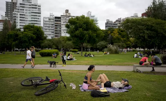 People hang out at a park in Rosario, Argentina, Monday, April 8, 2024. The birthplace of Lionel Messi and revolutionary Ernesto “Che” Guevara morphed about a decade ago into the country’s drug trafficking hub, as regional crackdowns pushed the trade south. (AP Photo/Natacha Pisarenko)