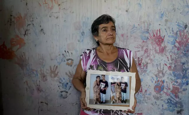 Geronima Benitez holds a photograph of her son Victor Emanuel, 17, who was murdered by drug traffickers who were never arrested two years ago, at her home in Rosario, Argentina, Tuesday, April 9, 2024. Benítez said her son’s killer still lives down her street and is not convinced a prison sentence would make a difference. “We, on the outside, live in prison,” she said. “Those inside have everything.” (AP Photo/Natacha Pisarenko)
