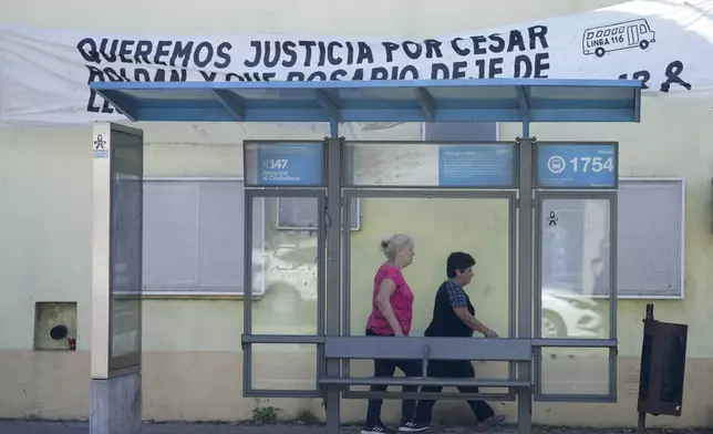 A banner hangs over a bus stop asking for justice regarding the murder of bus driver Cesar Roldan in Rosario, Argentina, Tuesday, April 9, 2024. (AP Photo/Natacha Pisarenko)