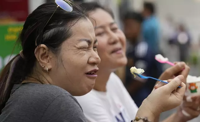 FILE - Women eat ice cream in Bangkok, Thailand, on April 9, 2024. Southeast Asia is coping with a weekslong heat wave as record-high temperatures have led to school closings in several countries and urgent health warnings throughout the region. (AP Photo/Sakchai Lalit, File)
