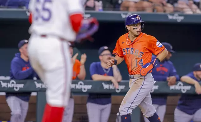 Houston Astros' Mauricio Dubón (14) rounds third base to score on a three-run home run by Victor Caratini during the fifth inning of a baseball game against the Texas Rangers, Monday, April 8, 2024, in Arlington, Texas. (AP Photo/Gareth Patterson)