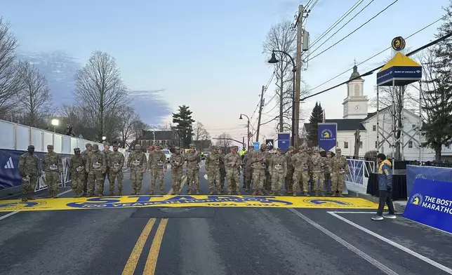 Boston Marathon Race Director Dave McGillivray, right, sends a group of Massachusetts National Guard members across the start line in Hopkinton on Monday, April 15, 2024 to begin the marathon. The start line was painted in honor of the town that has hosted the marathon for the past century. It's the 128th edition of the world’s oldest and most prestigious annual marathon. (AP Photo/Jennifer McDermott)
