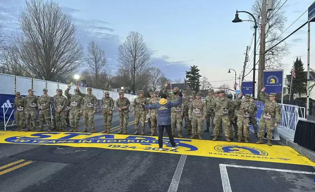 Boston Marathon Race Director Dave McGillivray sends a group of Massachusetts National Guard members across the start line in Hopkinton on Monday, April 15, 2024 to begin the marathon. The start line was painted in honor of the town that has hosted the marathon for the past century. It's the 128th edition of the world’s oldest and most prestigious annual marathon. (AP Photo/Jennifer McDermott)