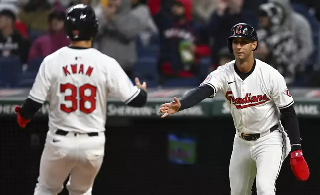 Cleveland Guardians' Steven Kwan (38) and Brayan Rocchio celebrate scoring on a single by Andrés Giménez during the fifth inning of the team's baseball game against the Oakland Athletics, Friday, April 19, 2024, in Cleveland. (AP Photo/Nick Cammett)