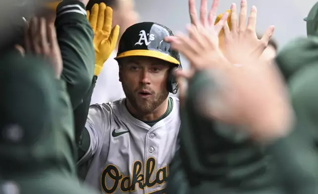 Oakland Athletics' Max Schuemann is congratulated for his solo home run off Cleveland Guardians starting pitcher Logan Allen, his first homer in the majors, during the fifth inning of a baseball game Saturday, April 20, 2024, in Cleveland. (AP Photo/Nick Cammett)