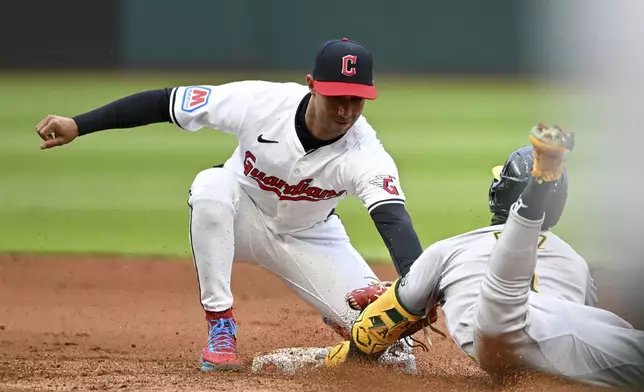 Cleveland Guardians' Brayan Rocchio tags out Oakland Athletics' Esteury Ruiz at second base as Ruiz attempted to stretch a single into a double during the fifth inning of a baseball game Saturday, April 20, 2024, in Cleveland. (AP Photo/Nick Cammett)