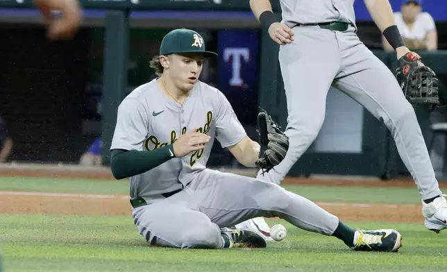 Oakland Athletics second base Zack Gelof (20) fails to make catch on a bloop hit by Texas Rangers' Jared Walsh (not shown) during the seventh inning of a baseball game Thursday, April 11, 2024, in Arlington, Texas. (AP Photo/Michael Ainsworth)