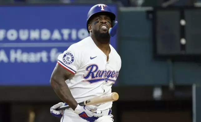 Texas Rangers outfielder Adolis García reacts after a follow through of a strike from the Oakland Athletics during the fourth inning of a baseball game Thursday, April 11, 2024, in Arlington, Texas. (AP Photo/Michael Ainsworth)