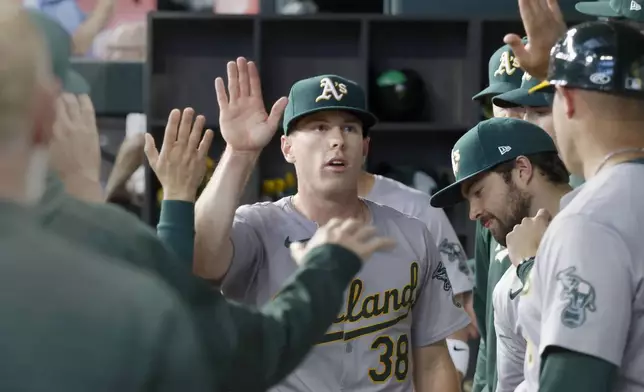 Oakland Athletics pitcher JP Sears (38) is greeted in the dugout after being pulled from a baseball game against the Texas Rangers during the seventh inning Thursday, April 11, 2024, in Arlington, Texas. (AP Photo/Michael Ainsworth)