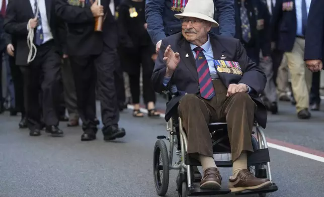 A veteran waves to the crowd during the Anzac Day parade in central the business district of Sydney, Australia, Thursday, April 25, 2024. (AP Photo/Mark Baker)