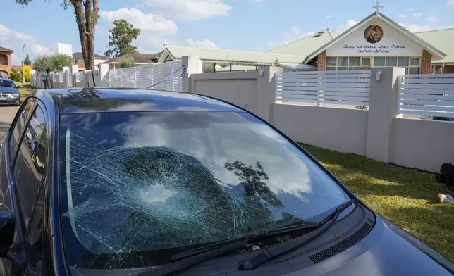 A damaged car sits parked outside the Christ the Good Shepherd church in suburban Wakely in western Sydney, Australia, Tuesday, April 16, 2024. Australian police say a knife attack in Sydney that wounded a bishop and a priest during a church service as horrified worshippers watched online and in person, and sparked a riot was an act of terrorism. (AP Photo/Mark Baker)