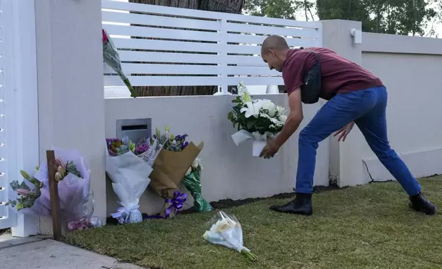A man places flowers outside the Christ the Good Shepherd church in suburban Wakely in western Sydney, Australia, Tuesday, April 16, 2024. Australian police say a knife attack in Sydney that wounded a bishop and a priest during a church service as horrified worshippers watched online and in person, and sparked a riot was an act of terrorism. (AP Photo/Mark Baker)