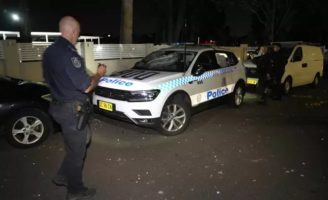 Police officers check vandalized vehicles outside a church where a bishop and churchgoers were reportedly stabbed in Sydney Australia, Monday, April 15, 2024. Police in Australia say a man has been arrested after a bishop and churchgoers were stabbed in the church. There are no life-threatening injuries. (AP Photo/Mark Baker)
