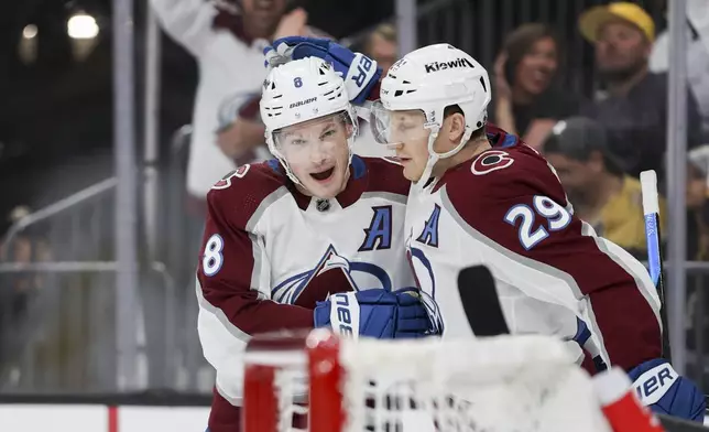Colorado Avalanche defenseman Cale Makar (8) and center Nathan MacKinnon (29) celebrate after Makar's goal against the Vegas Golden Knights during the first period of an NHL hockey game, Sunday, April 14, 2024, in Las Vegas. (AP Photo/Ian Maule)