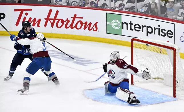 Winnipeg Jets' Mark Scheifele (55) scores on Colorado Avalanche goaltender Alexandar Georgiev (40) as Colorado's Jack Johnson (3) defends during the second period in Game 2 of an NHL hockey Stanley Cup first-round playoff series Tuesday, April 23, 2024, in Winnipeg, Manitoba. (Fred Greenslade/The Canadian Press via AP)