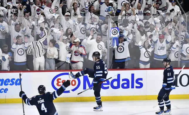 Winnipeg Jets' Mark Scheifele (55) celebrates his goal against the Colorado Avalanche with Neal Pionk (4) and Kyle Connor (81) during the second period in Game 2 of an NHL hockey Stanley Cup first-round playoff series Tuesday, April 23, 2024, in Winnipeg, Manitoba. (Fred Greenslade/The Canadian Press via AP)