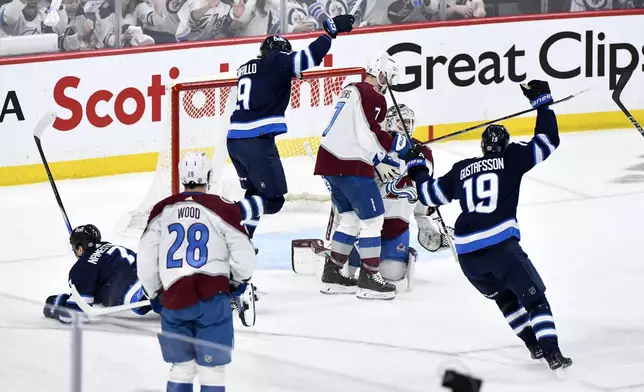 Winnipeg Jets' Alex Iafallo (9) and David Gustafsson (19) celebrate a goal by Vladislav Namestnikov (7) on Colorado Avalanche goaltender Alexandar Georgiev (40) during the first period in Game 1 of an NHL hockey Stanley Cup first-round playoff series in Winnipeg, Manitoba, on Sunday, April 21, 2024. (Fred Greenslade/The Canadian Press via AP)