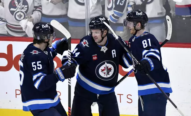 Winnipeg Jets left wing Kyle Connor (81) celebrates his goal against the Colorado Avalanche with teammates Mark Scheifele (55) and Josh Morrissey (44) during the third period in Game 1 of an NHL hockey Stanley Cup first-round playoff series in Winnipeg, Manitoba, Sunday, April 21, 2024. (Fred Greenslade/The Canadian Press via AP)