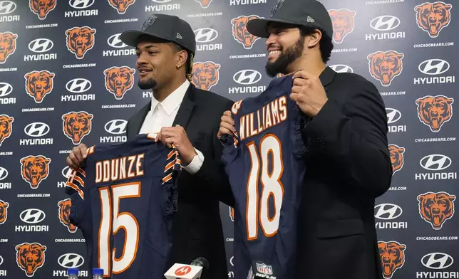 Chicago Bears draft picks wide receiver Rome Odunze, left, and quarterback Caleb Williams hold up jerseys during a news conference held by the NFL football team in Lake Forest, Ill., Friday, April 26, 2024. (AP Photo/Nam Y. Huh)