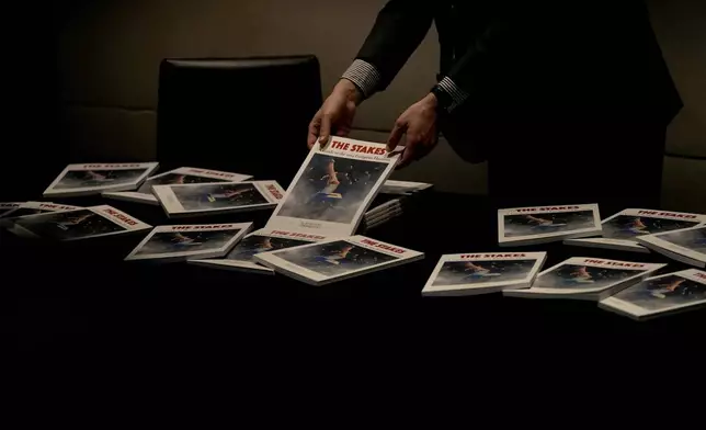 A man arranges pamphlets on a table during the National Conservatism conference in Brussels, Tuesday, April 16, 2024. (AP Photo/Virginia Mayo)