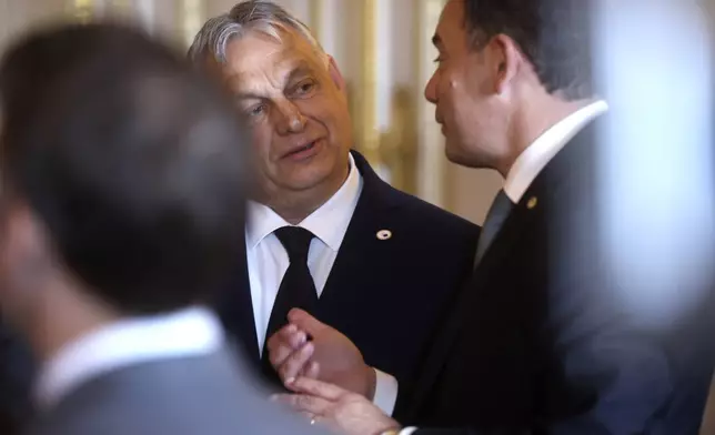 Hungary's Prime Minister Viktor Orban, center, speaks with Portugal's Prime Minister Luis Montenegro during a reception at the Royal Palace prior to an EU summit in Brussels, Wednesday, April 17, 2024. (Olivier Hoslet, Pool Photo via AP)