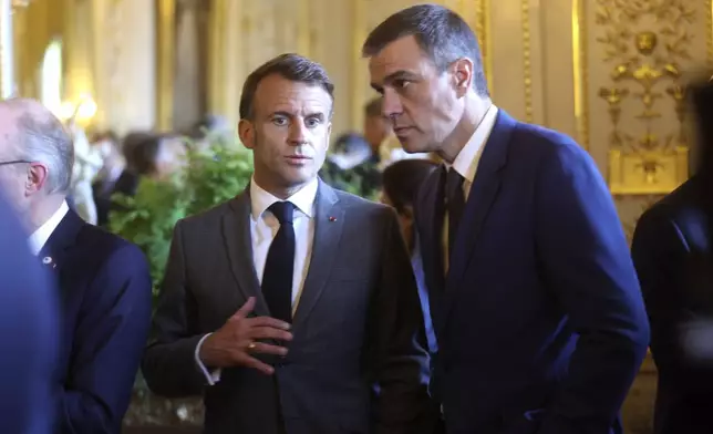French President Emmanuel Macron, left, speaks with Spain's Prime Minister Pedro Sanchez during a reception at the Royal Palace prior to an EU summit in Brussels, Wednesday, April 17, 2024. (Olivier Hoslet, Pool Photo via AP)