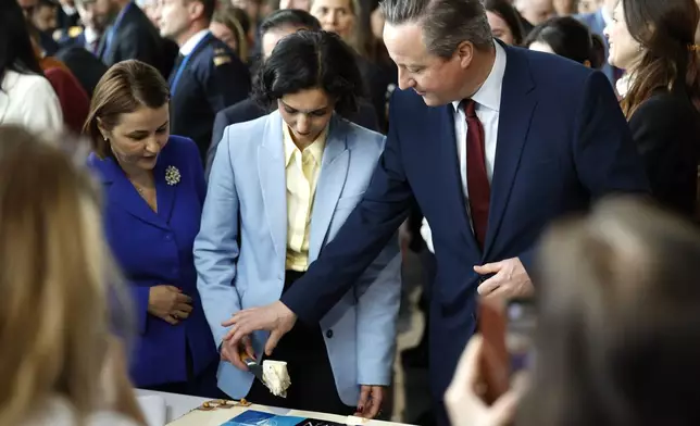 /from left, Romania's Foreign Minister Luminita-Teodora Odobescu, Belgium's Foreign Minister Hadja Lahbib and British Foreign Secretary David Cameron cut a cake during a ceremony to mark the 75th anniversary of NATO at NATO headquarters in Brussels, Thursday, April 4, 2024. NATO marked on Thursday 75 years of collective defense across Europe and North America, with its top diplomats vowing to stay the course in Ukraine as better armed Russian troops assert control on the battlefield. (AP Photo/Geert Vanden Wijngaert)