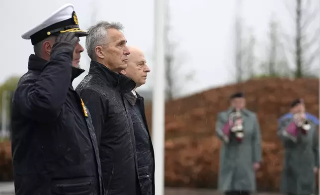 NATO Secretary General Jens Stoltenberg, center left, stands with NATO's Chairman of the Military Committee Admiral Rob Bauer and NATO Deputy Secretary General Mircea Geoana during a wreath laying ceremony at NATO headquarters in Brussels, Thursday, April 4, 2024. NATO celebrates on Thursday 75 years of collective defense across Europe and North America as Russia's war on Ukraine enters its third year. (AP Photo/Virginia Mayo)