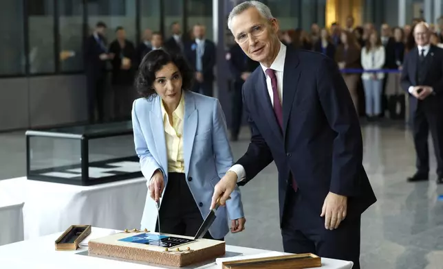 NATO Secretary General Jens Stoltenberg, right, and Belgium's Foreign Minister Hadja Lahbib cut a cake during a ceremony to mark the 75th anniversary of NATO at NATO headquarters in Brussels, Thursday, April 4, 2024. NATO marked on Thursday 75 years of collective defense across Europe and North America, with its top diplomats vowing to stay the course in Ukraine as better armed Russian troops assert control on the battlefield. (AP Photo/Geert Vanden Wijngaert)