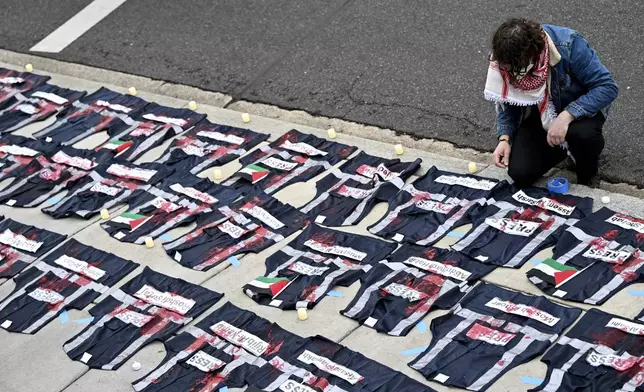 A demonstrator lays candles on the ground next to press vest covered in red paint during a pro-Palestinian protest over the Israel-Hamas war at the White House Correspondents' Association Dinner at the Washington Hilton, Saturday April 27, 2024, in Washington. (AP Photo/Terrance Williams)