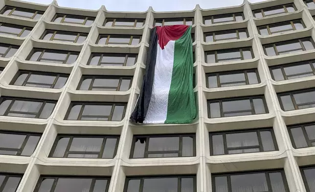 A Palestinian flag hangs on the side of the Washington Hilton as demonstrators protest the Israel-Hamas war before the start of the White House Correspondents' Association Dinner, Saturday, April 27, 2024, in Washington. (AP Photo/Pablo Martinez Monsivais)
