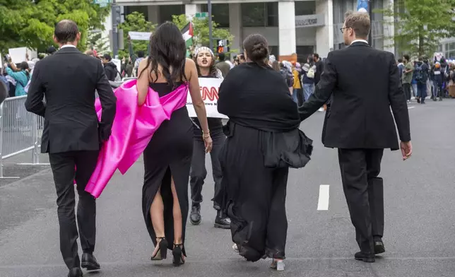 A demonstrator protests as guests arrive at the White House Correspondents Association Dinner at the Washington Hilton on Saturday, April 27, 2024, in Washington. (AP Photo/Kevin Wolf)