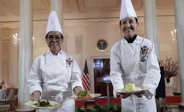 White House Executive Chef Cris Comerford, left, and White House Executive Pastry Chef Susie Morrison, right, hold the dishes to be served during a press preview at the White House in Washington, Tuesday, April 9, 2024, for the State Dinner for Japan's Prime Minister Fumio Kishida on Wednesday. (AP Photo/Susan Walsh)