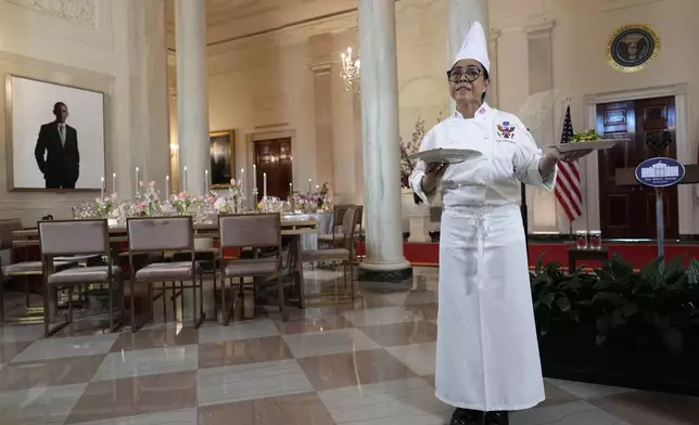White House Executive Chef Cris Comerford holds the dishes to be served during a press preview at the White House in Washington, Tuesday, April 9, 2024, for the State Dinner for Japan's Prime Minister Fumio Kishida on Wednesday. A portrait of former President Barrack Obama hangs in the White House, rear. (AP Photo/Susan Walsh)