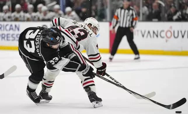 Los Angeles Kings right wing Viktor Arvidsson (33) and Chicago Blackhawks center Colin Blackwell (43) reach for the puck during the second period of an NHL hockey game Thursday, April 18, 2024, in Los Angeles. (AP Photo/Ashley Landis)