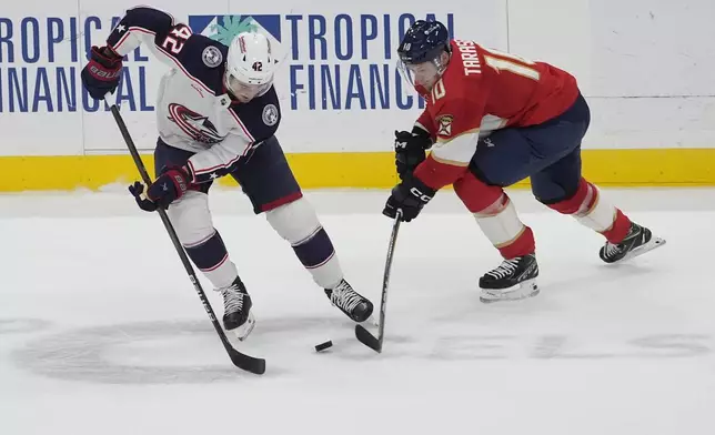 Columbus Blue Jackets center Alexandre Texier (42) and Florida Panthers right wing Vladimir Tarasenko (10) go after a puck during the first period of an NHL hockey game, Thursday, April 11, 2024, in Sunrise, Fla. (AP Photo/Marta Lavandier)