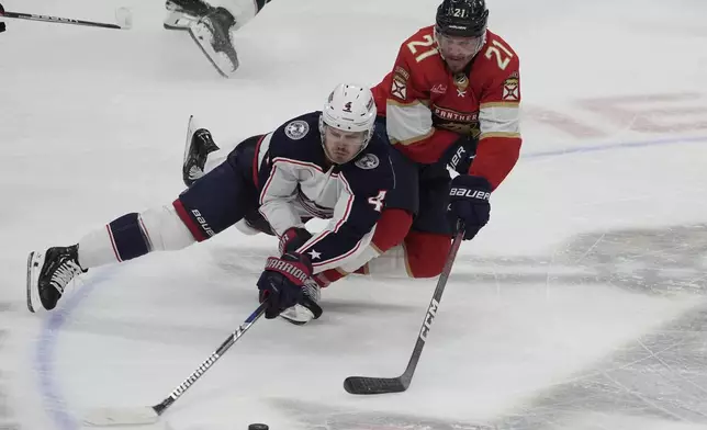 Columbus Blue Jackets center Cole Sillinger (4) and Florida Panthers center Nick Cousins (21) go after the puck during the second period of an NHL hockey game, Thursday, April 11, 2024, in Sunrise, Fla. (AP Photo/Marta Lavandier)
