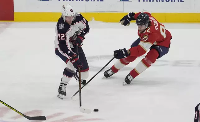 Columbus Blue Jackets left wing Alexander Nylander (92) gets control of the puck as Florida Panthers center Kevin Stenlund (82) defends during the first period of an NHL hockey game, Thursday, April 11, 2024, in Sunrise, Fla. (AP Photo/Marta Lavandier)
