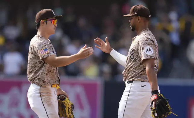 San Diego Padres second baseman Xander Bogaerts, right, celebrates with teammate shortstop Ha-Seong Kim after the Padres defeated the Toronto Blue Jays 6-3 in a baseball game, Sunday, April 21, 2024, in San Diego. (AP Photo/Gregory Bull)