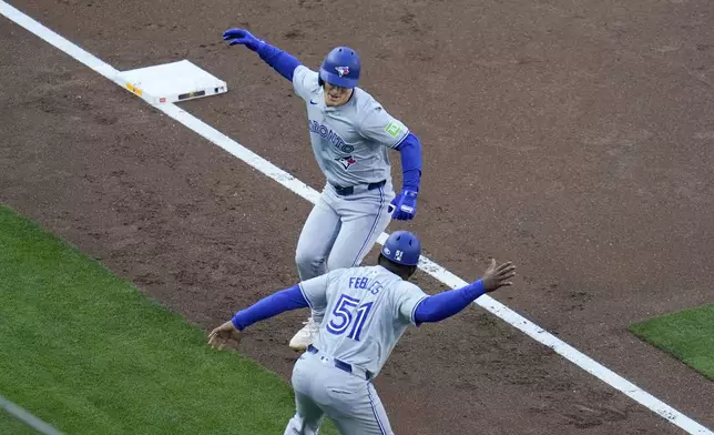 Toronto Blue Jays' Daulton Varsho, above, celebrates with third base coach Carlos Febles after hitting a three-run home run during the first inning of a baseball game against the San Diego Padres, Saturday, April 20, 2024, in San Diego. (AP Photo/Gregory Bull)
