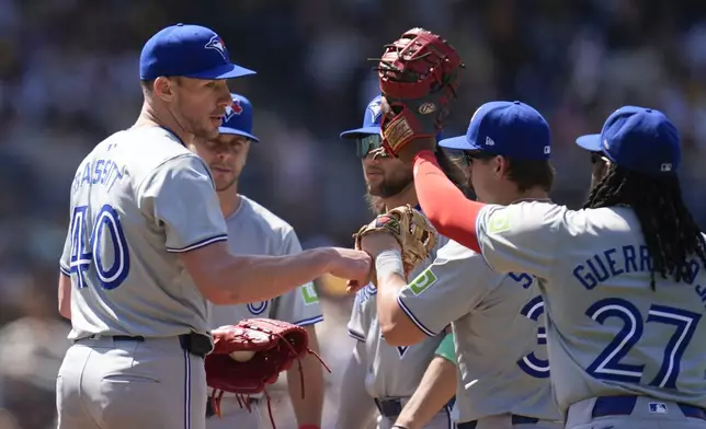 Toronto Blue Jays starting pitcher Chris Bassitt, left, celebrates with teammates before exiting during the sixth inning of a baseball game against the San Diego Padres, Sunday, April 21, 2024, in San Diego. (AP Photo/Gregory Bull)