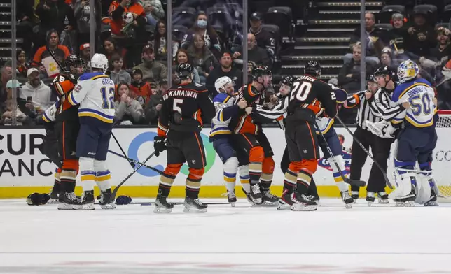 Members of the St. Louis Blues and the Anaheim Ducks fight during the second period of an NHL hockey game Sunday, April 7, 2024, in Anaheim, Calif. (AP Photo/Yannick Peterhans)