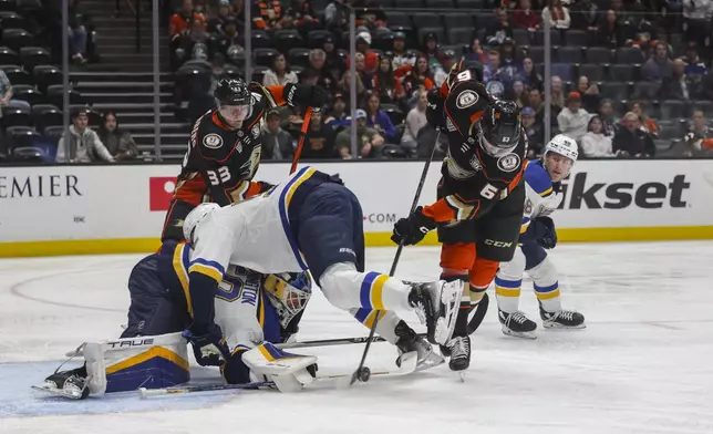 Anaheim Ducks center Nikita Nesterenko (62) scores as St. Louis Blues goalie Jordan Binnington, bottom left, defends during the first period of an NHL hockey game Sunday, April 7, 2024, in Anaheim, Calif. (AP Photo/Yannick Peterhans)