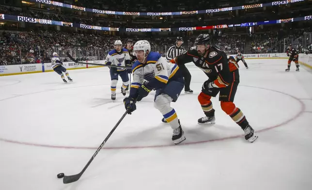 St. Louis Blues defensemen Mathew Kessel (51) moves the puck as Anaheim Ducks center Alex Killorn (17) defends during the first period of an NHL hockey game Sunday, April 7, 2024, in Anaheim, Calif. (AP Photo/Yannick Peterhans)
