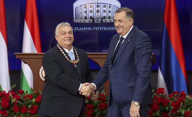 In this photograph made available by the Republika Srpska Presidential Press Service, Hungary's Prime Minister Viktor Orban, left, receives the Order of Republika Srpska from Bosnian Serb leader Milorad Dodik during his visit in Banja Luka, Bosnia, Friday, April 5, 2024. Orban is on a two-day visit to Bosnia and Herzegovina. (Republika Srpska Presidential Press Service via AP)