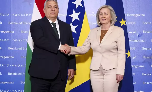 Hungarian Prime Minister Viktor Orban, left, shakes hands with the President of the Council of Ministers of Bosnia and Herzegovina Borjana Kristo prior to their meeting in Sarajevo, Bosnia, Thursday, April 4, 2024. (AP Photo)