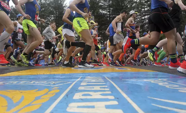 FILE - Runners cross the start line of the 123rd Boston Marathon on Monday, April 15, 2019, in Hopkinton, Mass. Once a year for the last 100 years, Hopkinton becomes the center of the running world, thanks to a quirk of geography and history that made it the starting line for the world's oldest and most prestigious annual marathon. (AP Photo/Stew Milne, File)