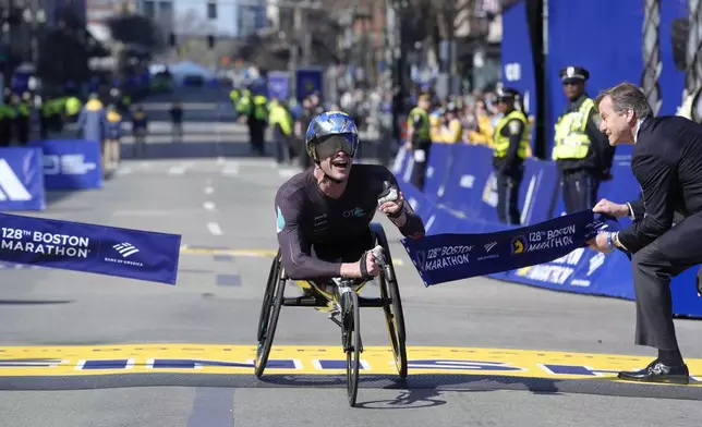 Marcel Hug, of Switzerland, breaks the tape to win the men's wheelchair division of the Boston Marathon, Monday, April 15, 2024, in Boston. (AP Photo/Steven Senne)