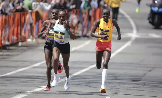 Kenya's Hellen Obiri, center, surges ahead of Sharon Lodeki, left, and Edna Kiplagat, right, just past mile 23 in Brookline, Mass., during the Boston Marathon, Monday April 15, 2024. Obiri won the women's division. (AP Photo/Jennifer McDermott)